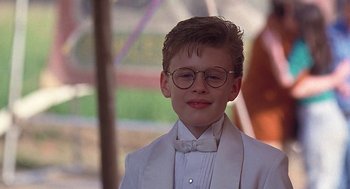 Movie still from “The Little Rascals” (1994), directed by Penelope Spheeris – A young boy in a white suit and bow tie; Close Up shot, Low angle