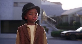 Movie still from “The Little Rascals” (1994), directed by Penelope Spheeris – A young boy wearing a hat and a jacket; Close Up shot, Low angle