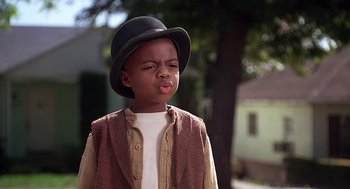 Movie still from “The Little Rascals” (1994), directed by Penelope Spheeris – A little boy wearing a black hat and a brown jacket; Close Up shot, High angle