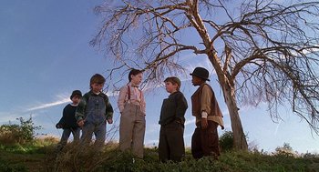 Movie still from “The Little Rascals” (1994), directed by Penelope Spheeris – A group of young boys standing next to a tree; Wide shot, Low angle