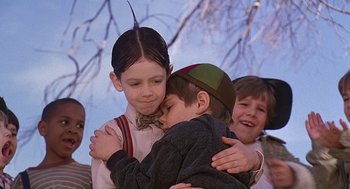 Movie still from “The Little Rascals” (1994), directed by Penelope Spheeris – Two children hugging each other while another child watches; Close Up shot, Over the shoulder angle