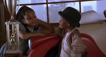 Movie still from “The Little Rascals” (1994), directed by Penelope Spheeris – Two young children sitting on a red bench; Close Up shot, High angle