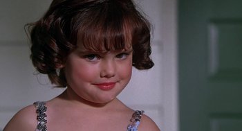 Movie still from “The Little Rascals” (1994), directed by Penelope Spheeris – A little girl with brown hair and blue eyes; Close Up shot, Over the shoulder angle
