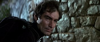 Movie still from “The Living Daylights” (1987), directed by John Glen – A man's face in front of a stone wall; Close Up shot, Low angle