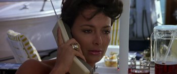 Movie still from “The Living Daylights” (1987), directed by John Glen – A person talking on a cell phone; Close Up shot, Low angle