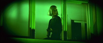 Movie still from “The Living Daylights” (1987), directed by John Glen – A woman standing in front of an open door; Medium shot, Low angle