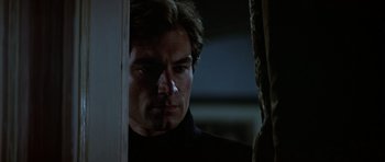 Movie still from “The Living Daylights” (1987), directed by John Glen – A person in a dark room; Close Up shot, Over the shoulder angle