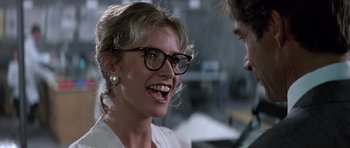 Movie still from “The Living Daylights” (1987), directed by John Glen – A woman wearing glasses talking to a man wearing glasses; Close Up shot, Over the shoulder angle