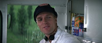 Movie still from “The Living Daylights” (1987), directed by John Glen – A person wearing headphones and a hat; Close Up shot, Low angle