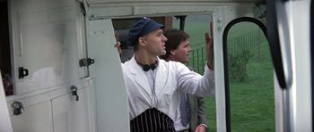 Movie still from “The Living Daylights” (1987), directed by John Glen – A man in a chef's outfit is standing next to another man in a suit; Medium shot, Low angle