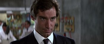 Movie still from “The Living Daylights” (1987), directed by John Glen – A man in a suit and a tie; Close Up shot, Over the shoulder angle