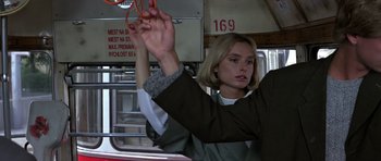 Movie still from “The Living Daylights” (1987), directed by John Glen – A woman holding a pair of scissors on a bus; Close Up shot, Low angle