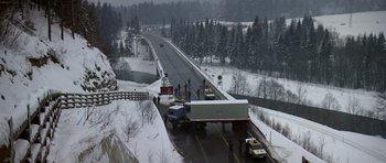 Movie still from “The Living Daylights” (1987), directed by John Glen – A semi truck on the side of a road; Extreme Wide shot, High angle