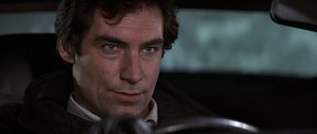 Movie still from “The Living Daylights” (1987), directed by John Glen – A person sitting in a car; Close Up shot, Over the shoulder angle