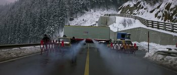 Movie still from “The Living Daylights” (1987), directed by John Glen – A man standing on the side of a road near a truck; Extreme Wide shot, High angle