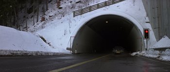 Movie still from “The Living Daylights” (1987), directed by John Glen – A car is driving through a tunnel in the snow; Extreme Wide shot, High angle
