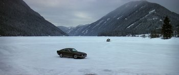 Movie still from “The Living Daylights” (1987), directed by John Glen – A car parked on top of a snow covered field; Extreme Wide shot, High angle