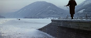 Movie still from “The Living Daylights” (1987), directed by John Glen – A view of a snowy mountain and a concrete wall; Extreme Wide shot, Low angle