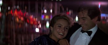 Movie still from “The Living Daylights” (1987), directed by John Glen – A young woman smiles brightly at the camera; Close Up shot, Low angle