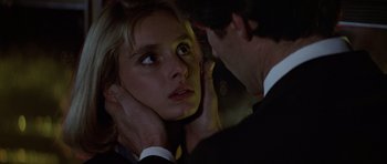 Movie still from “The Living Daylights” (1987), directed by John Glen – A man and a woman in a suit and tie; Close Up shot, Low angle
