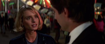 Movie still from “The Living Daylights” (1987), directed by John Glen – A man and a woman are talking in a crowd; Close Up shot, Over the shoulder angle