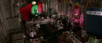Movie still from “The Living Daylights” (1987), directed by John Glen – An overhead view of people sitting at tables in a room; Wide shot, High angle