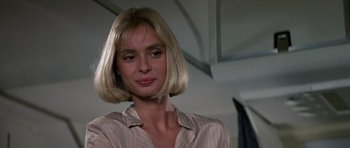 Movie still from “The Living Daylights” (1987), directed by John Glen – A woman with blonde hair wearing a white shirt; Close Up shot, Low angle