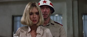 Movie still from “The Living Daylights” (1987), directed by John Glen – A woman standing next to a man in a uniform; Close Up shot, Low angle