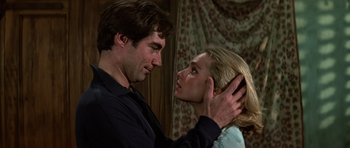 Movie still from “The Living Daylights” (1987), directed by John Glen – A man and a woman are touching their heads together; Close Up shot, Low angle