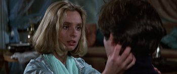 Movie still from “The Living Daylights” (1987), directed by John Glen – A young woman sitting in front of a young man; Close Up shot, Over the shoulder angle
