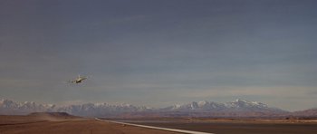 Movie still from “The Living Daylights” (1987), directed by John Glen – A view of a road and mountains in the distance; Extreme Wide shot, Low angle