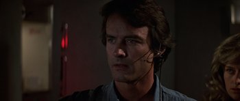 Movie still from “The Living Daylights” (1987), directed by John Glen – A person wearing a headset; Close Up shot, Low angle