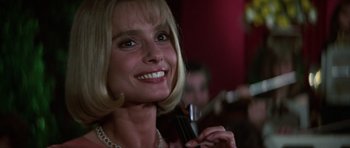 Movie still from “The Living Daylights” (1987), directed by John Glen – A person holding a wine glass; Close Up shot, Low angle