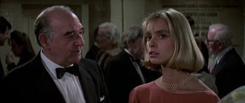 Movie still from “The Living Daylights” (1987), directed by John Glen – A man and a woman standing next to each other in a room; Close Up shot, Over the shoulder angle