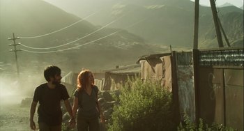 Movie still from “The Loneliest Planet” (2011), directed by Julia Loktev – Two people holding hands while walking on a hill; Wide shot, Low angle