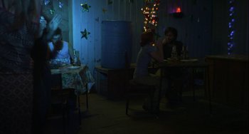 Movie still from “The Loneliest Planet” (2011), directed by Julia Loktev – A group of people sitting at a table in a room; Wide shot, Over the shoulder angle