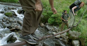 Movie still from “The Loneliest Planet” (2011), directed by Julia Loktev – A man standing next to another man in a stream; Wide shot, Low angle