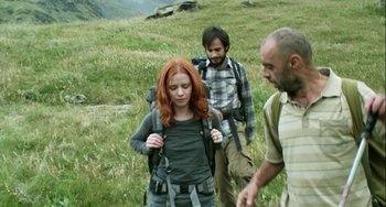 Movie still from “The Loneliest Planet” (2011), directed by Julia Loktev – A group of people walking through a grassy field; Medium shot, Low angle