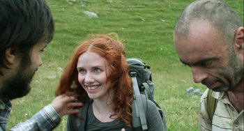 Movie still from “The Loneliest Planet” (2011), directed by Julia Loktev – A woman with red hair and a backpack on; Close Up shot, Over the shoulder angle
