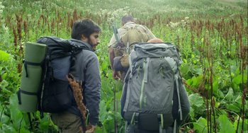 Movie still from “The Loneliest Planet” (2011), directed by Julia Loktev – A group of people with backpacks walking through a field; Medium shot, Low angle