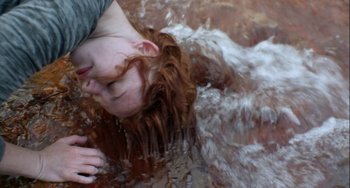 Movie still from “The Loneliest Planet” (2011), directed by Julia Loktev – A woman with long red hair is in the water; Close Up shot, Overhead angle