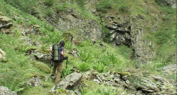 Movie still from “The Loneliest Planet” (2011), directed by Julia Loktev – A man with a backpack walking up a hill; Extreme Wide shot, High angle