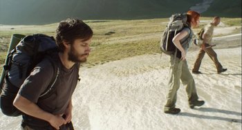 Movie still from “The Loneliest Planet” (2011), directed by Julia Loktev – A man standing on a dirt road next to another man; Medium shot, Low angle
