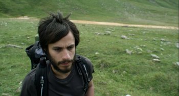Movie still from “The Loneliest Planet” (2011), directed by Julia Loktev – A man with a beard is standing in the grass; Close Up shot, High angle