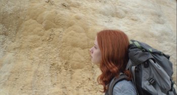 Movie still from “The Loneliest Planet” (2011), directed by Julia Loktev – A woman with a backpack walking on a dirt road; Close Up shot, Low angle