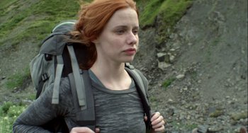 Movie still from “The Loneliest Planet” (2011), directed by Julia Loktev – A woman with red hair is walking with a backpack; Close Up shot, Low angle