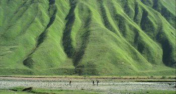 Movie still from “The Loneliest Planet” (2011), directed by Julia Loktev – A group of people standing on top of a grass covered hillside; Extreme Wide shot, High angle