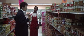 Movie still from “The Long Goodbye” (1973), directed by Robert Altman – Two people in a grocery store talking to each other; Medium shot, Low angle
