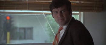 Movie still from “The Long Goodbye” (1973), directed by Robert Altman – A person wearing a suit and tie; Close Up shot, Low angle