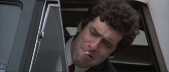 Movie still from “The Long Goodbye” (1973), directed by Robert Altman – A person smoking a cigarette near a computer; Close Up shot, Low angle
